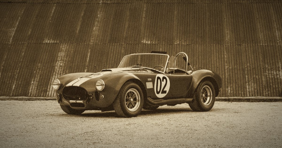 Shelby Cobra bleue à bandes blanches, devant un mur en tôle rouillée