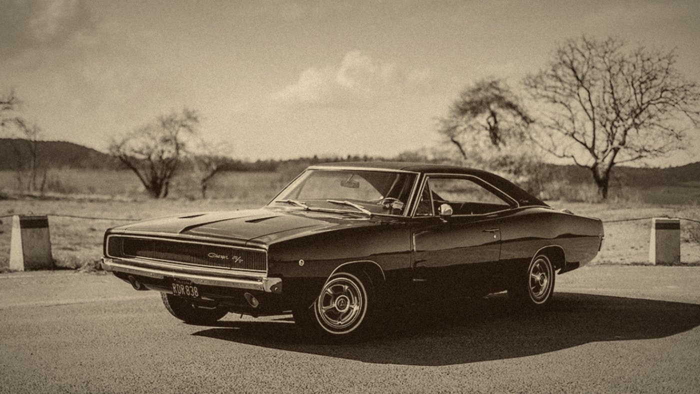 Dodge Charger R/T noire, vue de trois-quarts avant, sur une route de campagne